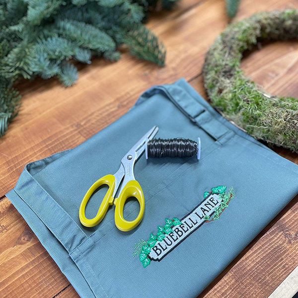 Bluebell Lane logo embroided on an apron